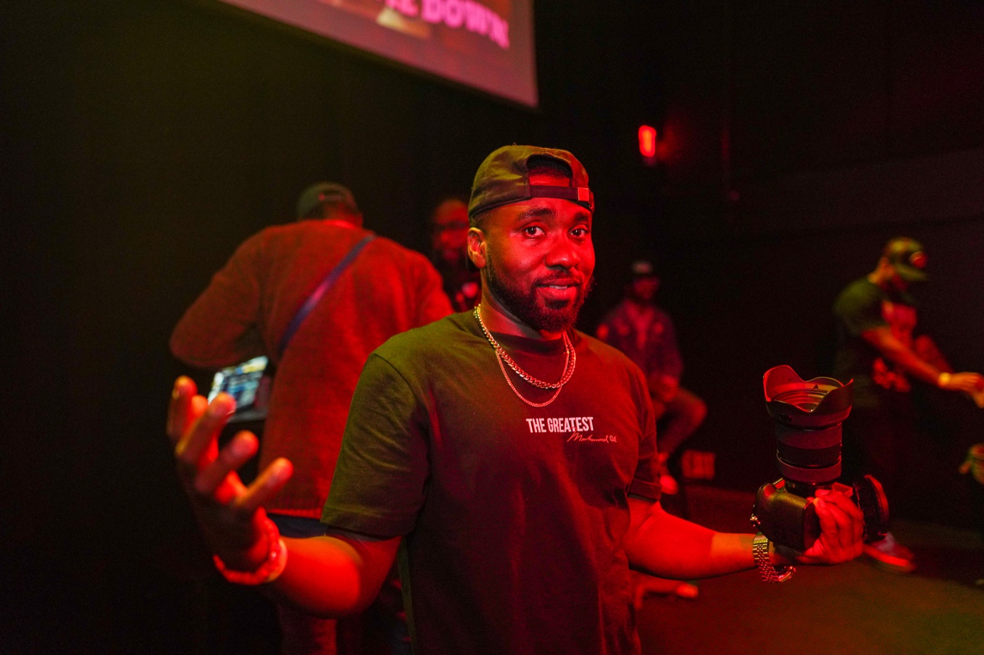 DJ OMG PRINCE mid-set at Crybaby, camo cap and gold chain, red stage lighting